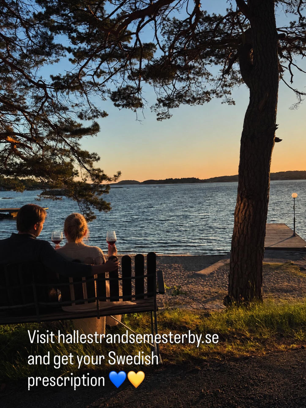Två personer kollar på en solnedgång vid havet
